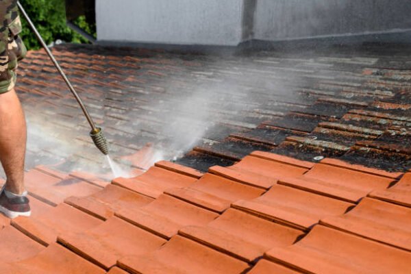 Process of washing rooftop. Before and after situation. Dirt and lichen removed from surface with special equipment. Clean roof tiles.